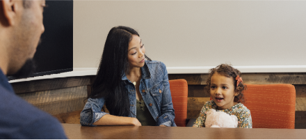 Mother and daughter sitting with Lake Trust team member.